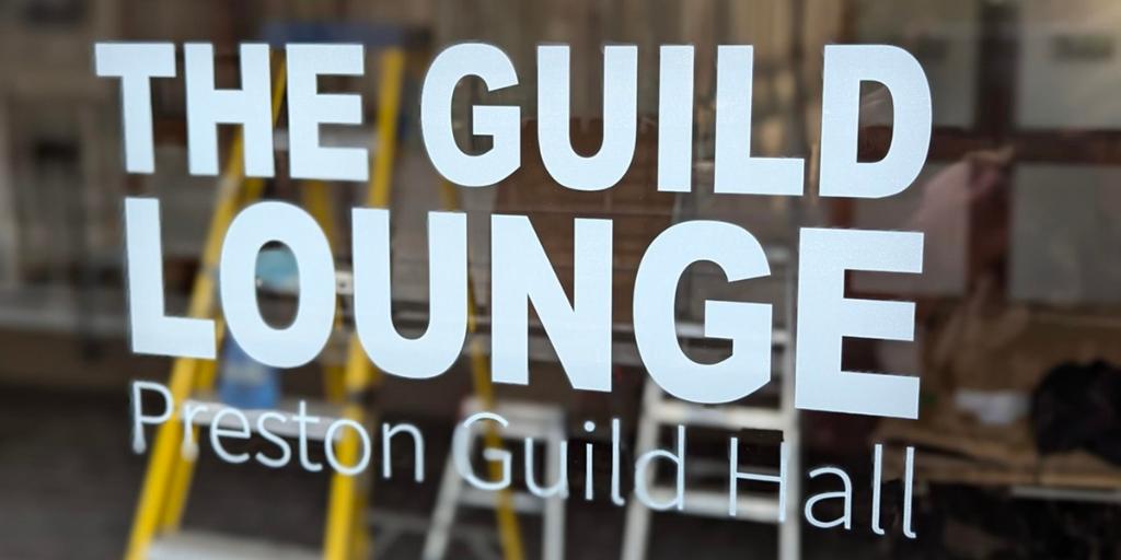 The Guild Lounge Window Sign A sign on a glass window saying The Guild Lounge