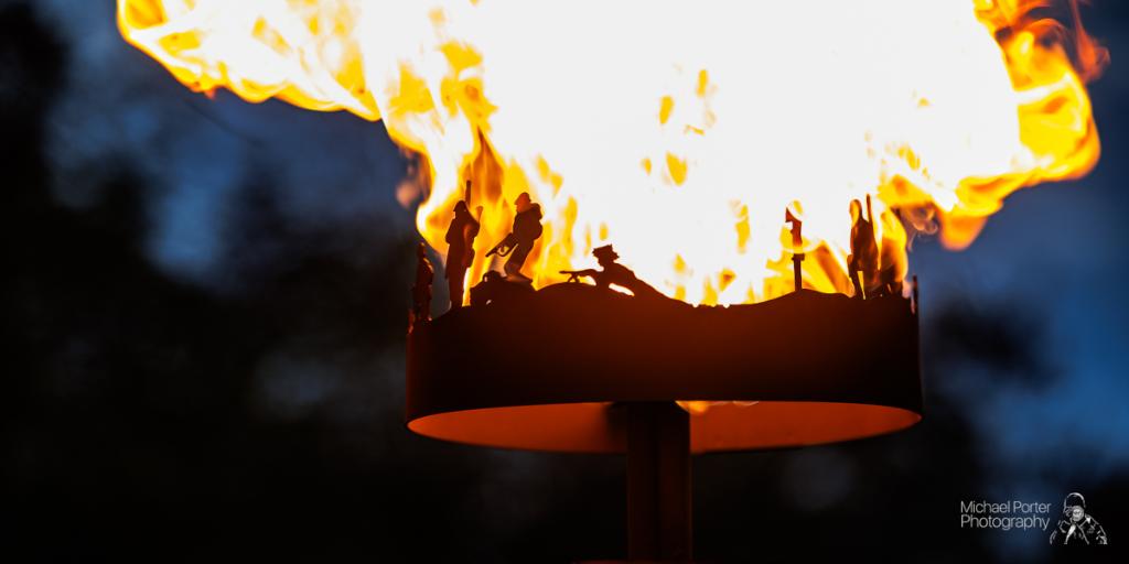 Beacon Lighting - metal beacon on fire A metal beacon with a fire lit inside it with depictions of soldiers around the rim