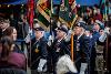 Veterans of wars standing at attention with parade flags during a memorial ceremony in Preston